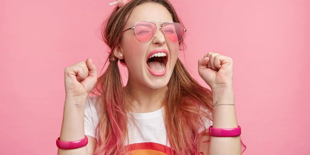 Overjoyed woman against a pink background