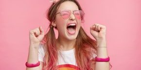 Overjoyed woman against a pink background