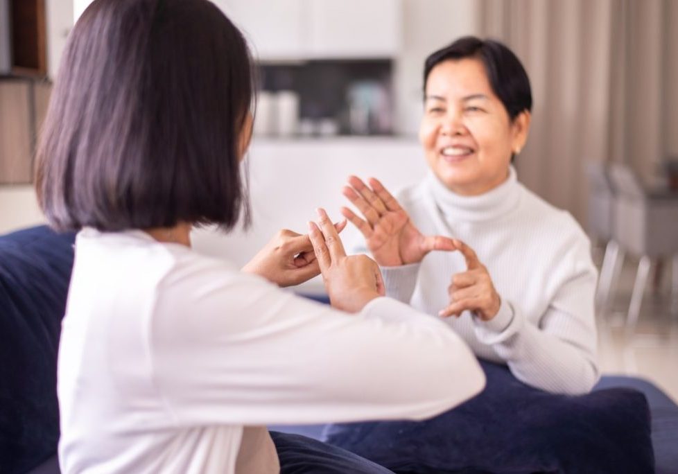 Two women converse using sign language